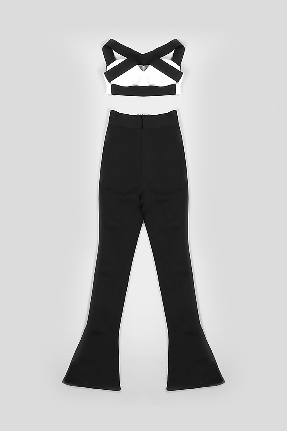 Conjunto de dos piezas con pantalones ajustados negros y tirantes cruzados con camisola blanca