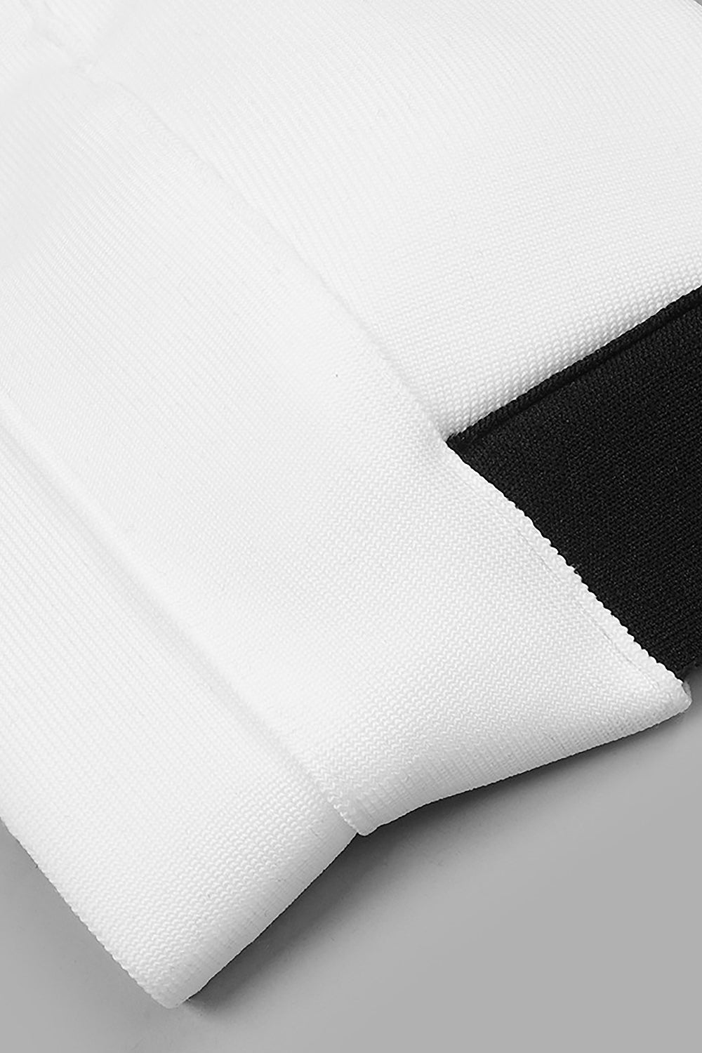 Conjunto de dos piezas con pantalones ajustados negros y tirantes cruzados con camisola blanca